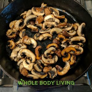 cooking keto breakfast frittata mushrooms in cast iron skillet