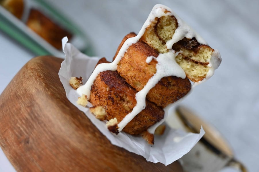 keto Coffee Cake Muffins stacked on top of each other with icing running down the side of the muffins